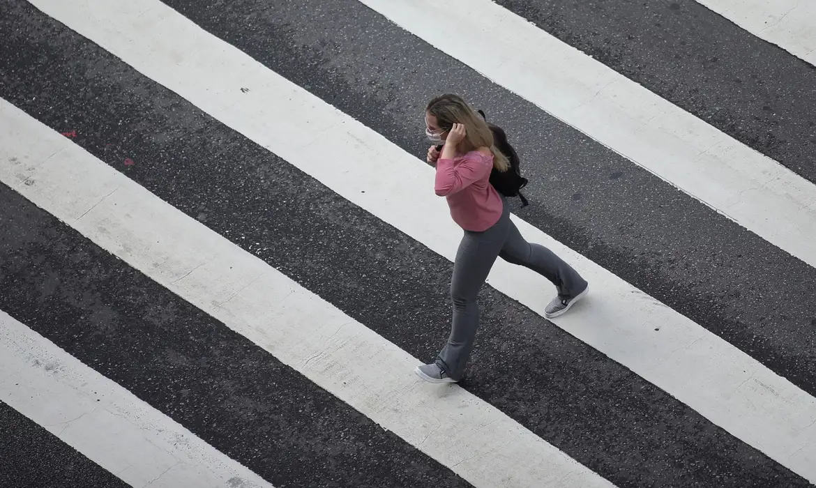 REUTERS/Rahel Patrasso/Direitos reservados Mulher com máscara de proteção em avenida de São Paulo