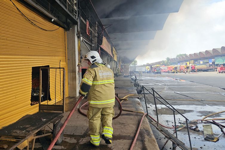 Rio de Janeiro (RJ), 03/12/2025 - Soldado do Corpo de Bombeiro joga água para conter incêndio em galpão da Ceasa. Foto: CBEMRJ/Divulgação